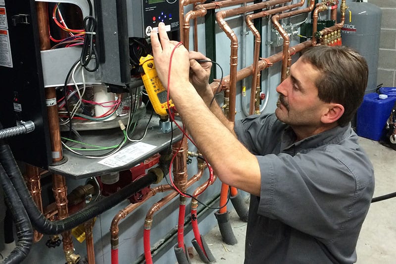 An HVAC technician performs a maintenance check 