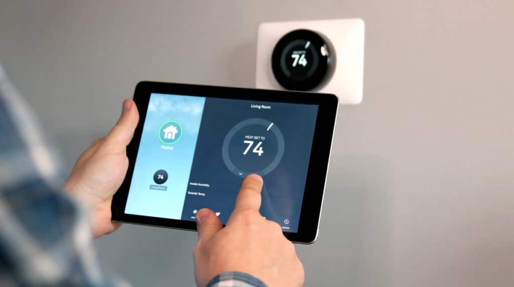 Man adjusting temperature using a tablet with smart home app