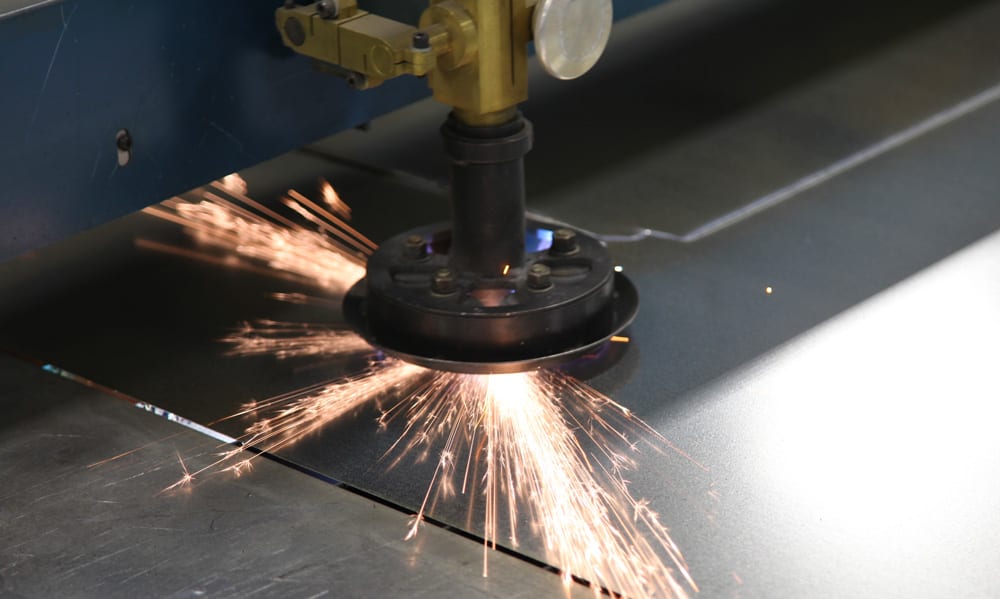 A closeup of machinery cutting a piece of sheet metal