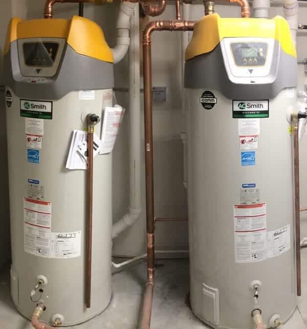 Two commercial water heaters against a wall