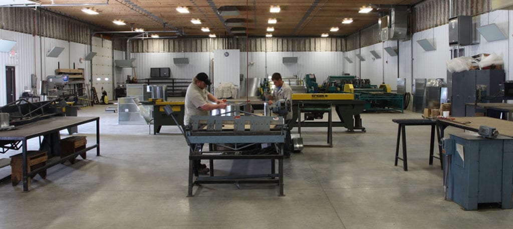 Two sheet metal fabrication technicians working in Custom Aire’s sheet metal shop