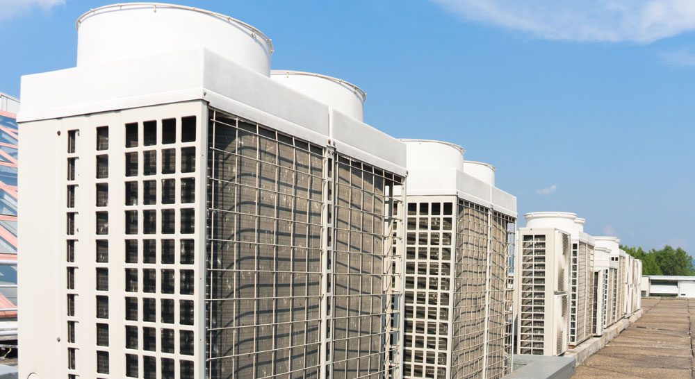 A row of variable refrigerant flow (VRF) air conditioning units on a rooftop of a building.
