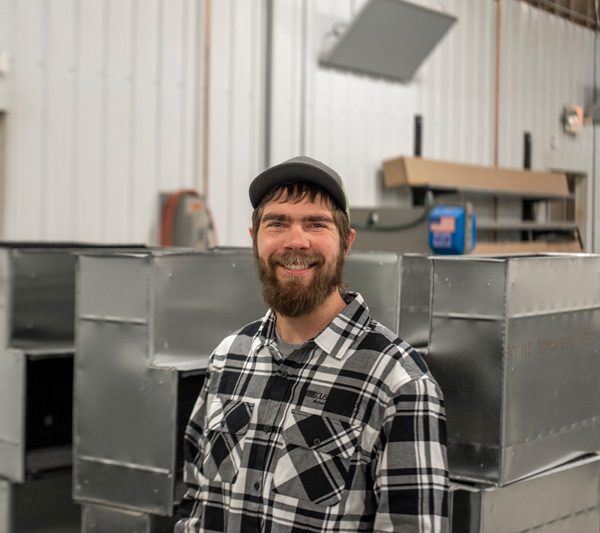 Sheet metal fabricator smiling confidently at the camera