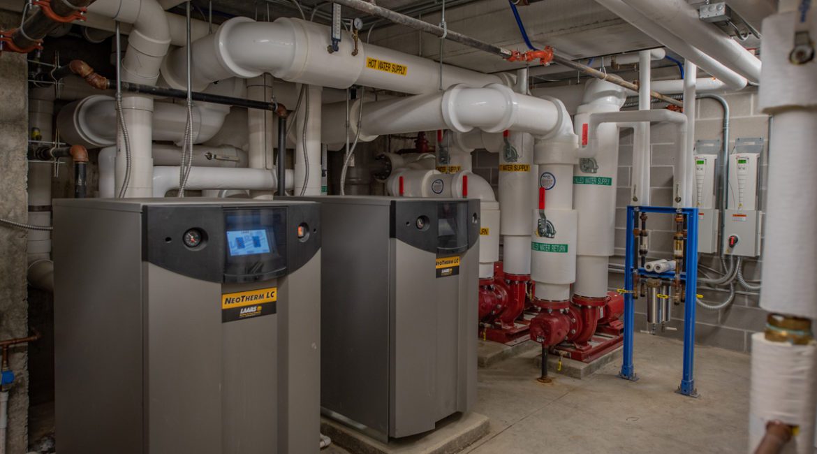 Hydronic water heaters in the plant room of a large apartment building.
