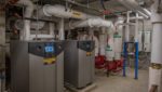 Hydronic water heaters in the plant room of a large apartment building.