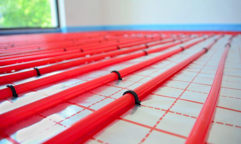PEX pipes for radiant floor heating laid across a subfloor.